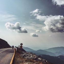 People on country road along mountain range