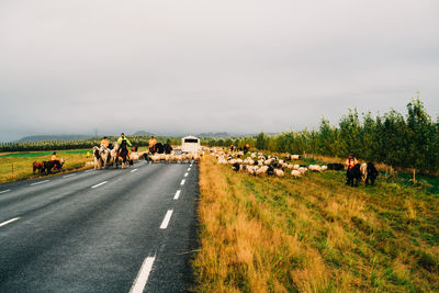 Group of people on road along landscape