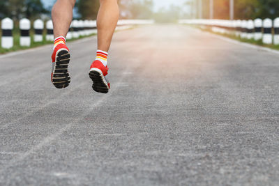 Low section of man jumping on road