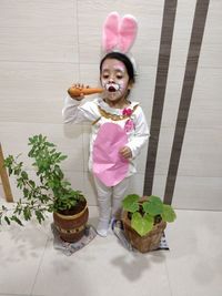 Portrait of girl holding potted plant