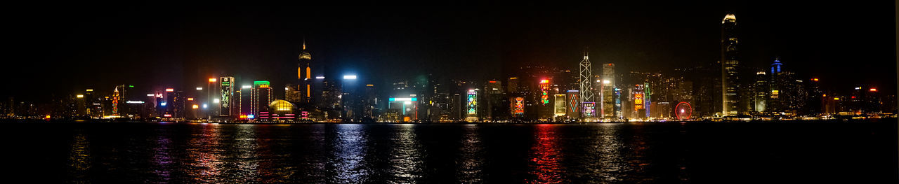 Illuminated buildings by river at night