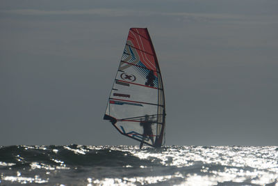 Low angle view of sailboat against sea against sky