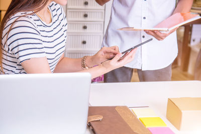 Midsection of woman working on table