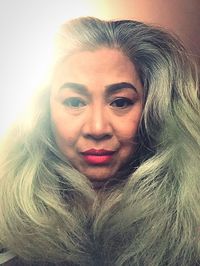 Close-up portrait of young woman against gray background