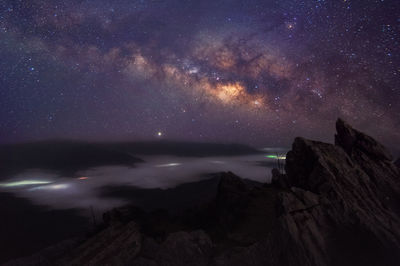 Scenic view of rock formation against sky at night