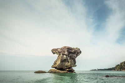 Scenic view of rock formation in sea against sky