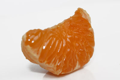 Close-up of orange slice against white background