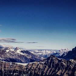 Scenic view of snowcapped mountains against blue sky