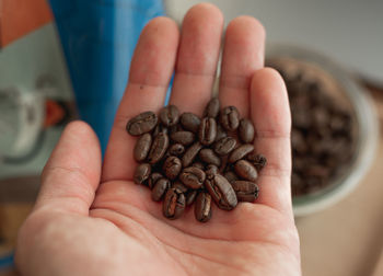 Close-up of hand holding coffee beans