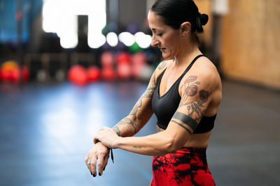 Side view of young woman exercising in city