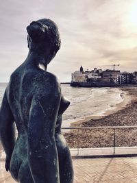 Close-up of statue against sea in city