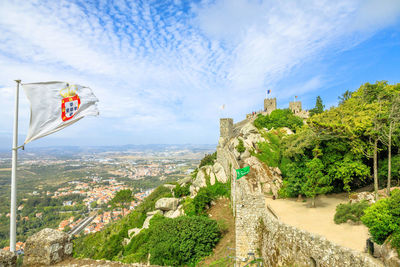 Low angle view of flags on rock against sky