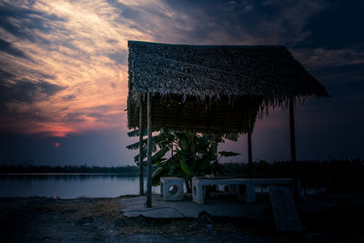 Lifeguard hut on beach against sky during sunset