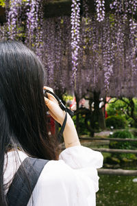 Midsection of woman holding red flowering plant