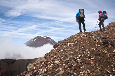 Silhouette of man standing on mountain against sky