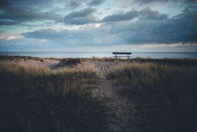 Scenic view of beach against cloudy sky