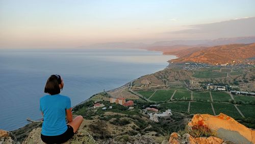 Rear view of woman looking at sea against sky