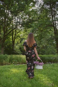 Rear view of woman standing on field