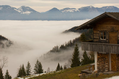 Scenic view of house and mountains against sky