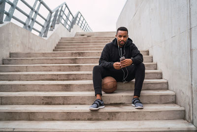 Full length of man sitting on staircase