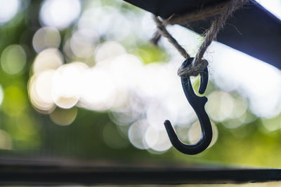 Close-up of hook tied to railing