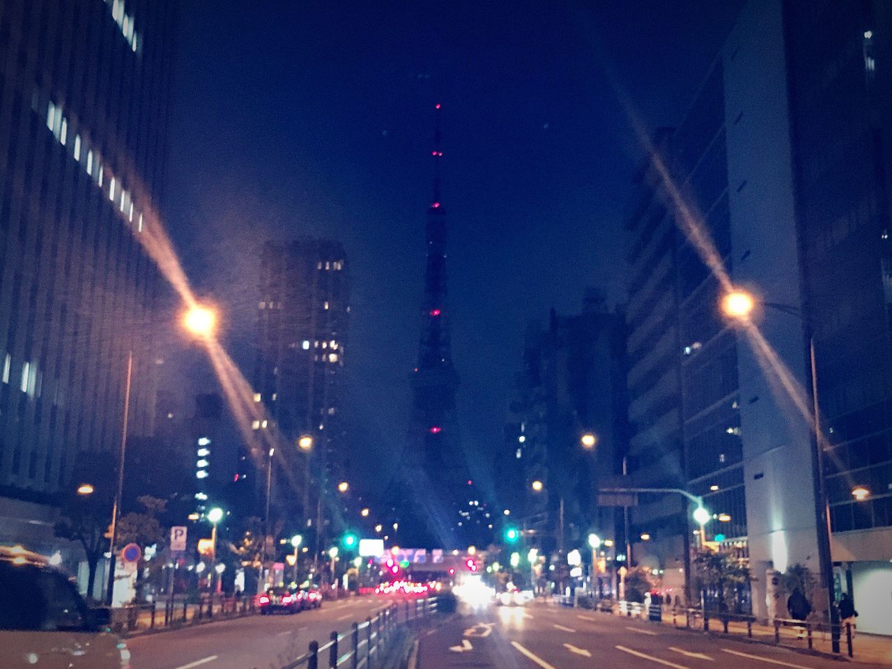 illuminated, night, city, architecture, built structure, road, street light, city street, mode of transport, city life, the way forward, traffic, sky, diminishing perspective, headlight, outdoors, vanishing point, no people, cityscape, tall - high, travel destinations