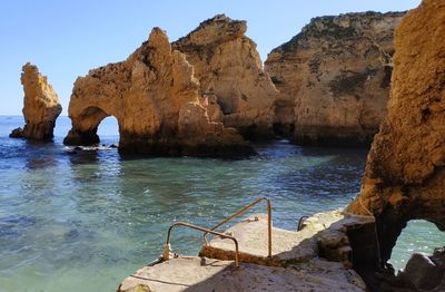 Rock formations by sea against sky