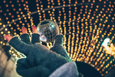 Low section of man holding umbrella at night