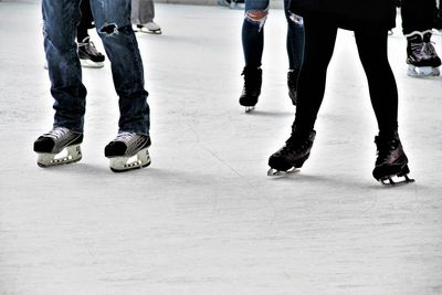 Low section of people walking on snow