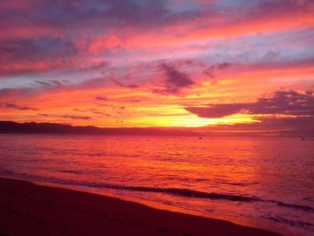 Scenic view of sea against dramatic sky during sunset