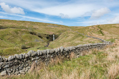 An ascent to the whernside peak with a waterfall in the distance, yorkshire three peaks challenge