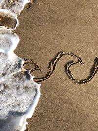 High angle view of heart shape on sand at beach