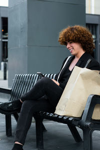 Young woman using laptop while sitting on chair