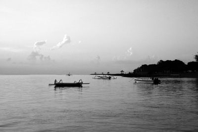 Silhouette boat sailing in sea against sky