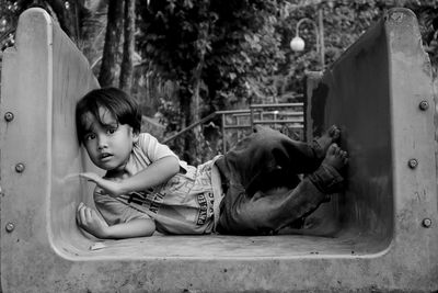 Portrait of cute boy on old slide in playground