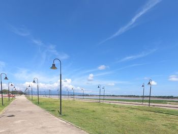 Street amidst field against sky