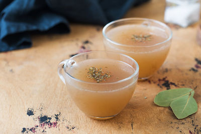 Homemade bone broth in a mugs on a wooden table. the concept of healthy food.