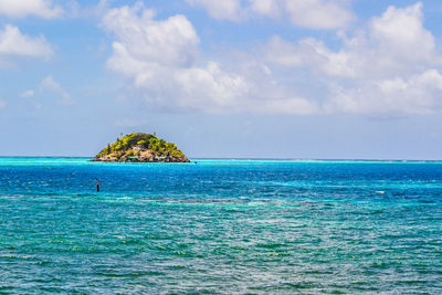 Scenic view of island against cloudy sky