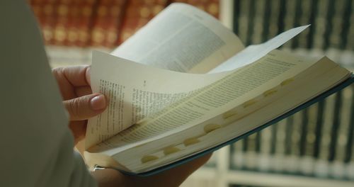 Woman self-taught reading a book in library.  pages of an open paper holy bible. education concept.