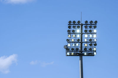 Low angle view of floodlight against blue sky