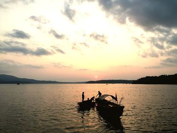 Silhouette of boat in sea against sky during sunset