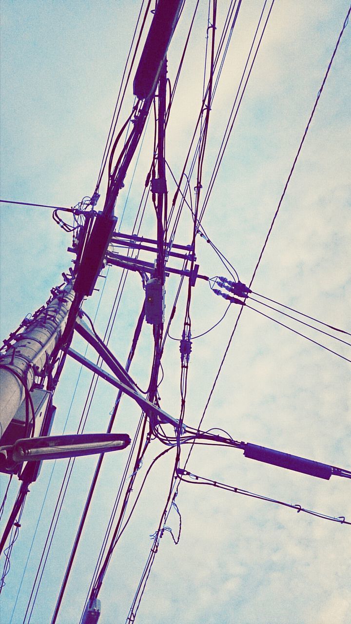 low angle view, power line, cable, power supply, built structure, architecture, electricity, electricity pylon, connection, sky, fuel and power generation, building exterior, blue, day, hanging, complexity, rope, technology, no people, outdoors