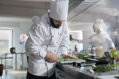 Chef wearing uniform cooking food at restaurant