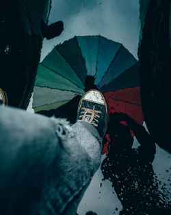 Low section of man standing on puddle