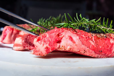Close-up of a wagyu ribeye with rosemary and a fork on a plate 