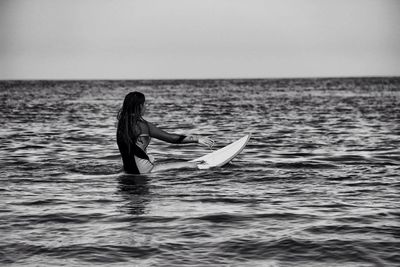 Woman in sea against sky