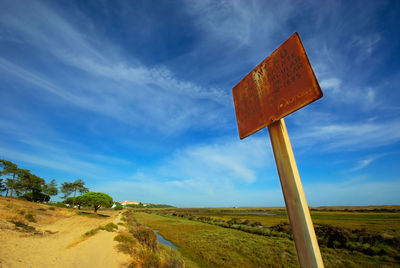 An old rusty warning sign in formosa natural reserve area, algarve, portugal