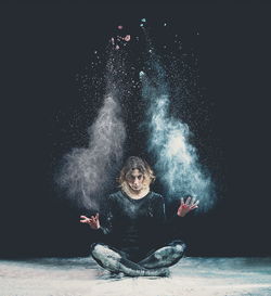 Creative portrait of young woman against black background