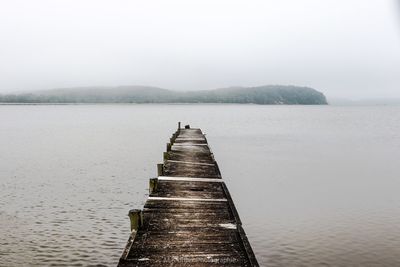 Pier over lake against sky
