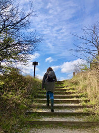 Rear view of woman walking on staircase